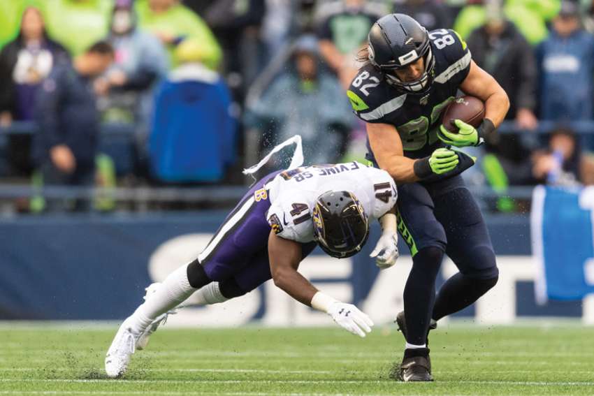 Seattle Seahawks’ tight end Luke Willson, at right and in action above, will be receiving Assumption University’s Christian Culture Gold Medal later this year.