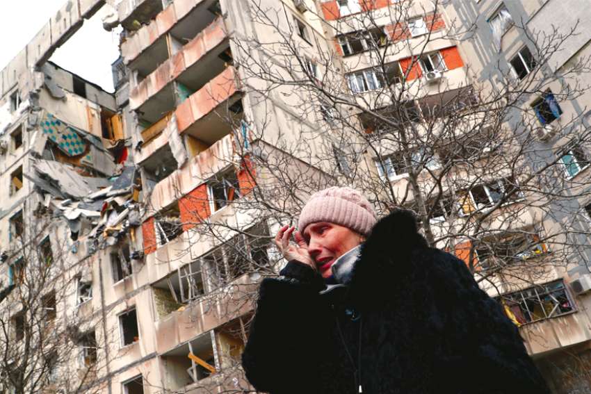 A woman cries in front of destroyed apartment buildings in Mariupol, Ukraine.