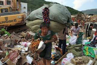 An earthquake survivor carries his belongings Aug. 6 in China&#039;s Yunnan province. As Chinese authorities raised the official death toll from the Aug. 3 quake, Pope Francis offered public prayers for the victims and their families.