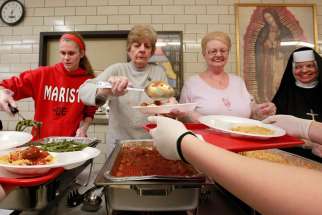 Volunteers serve meals at a soup kitchen.