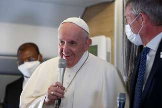 Pope Francis speaks with journalists aboard his flight from Baghdad to Rome March 8, 2021. At right is Matteo Bruni, director of the Holy See Press Office.