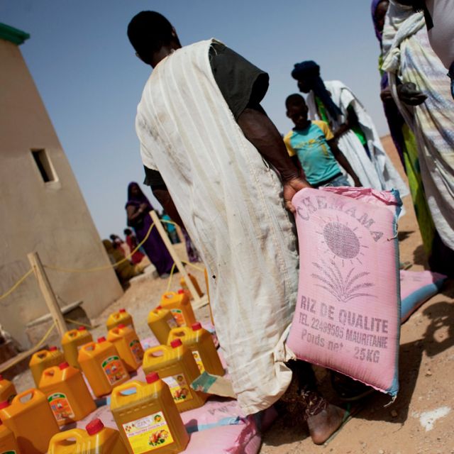 A man walks away with a bag of rice at a food distribution center run by the aid group Action Against Hunger in Tarenguel, Mauritania, May 30. U.N. agencies estimate that 18 million people in West Africa&#039;s Sahel region are at risk of hunger because of drought, conflict and rising food prices.