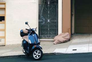 A homeless person sleeps under a sheet in San Francisco. 