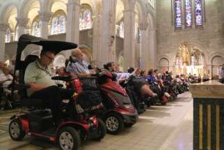 Pilgrims in wheelchairs, including some from the Ahearn Memorial Pilgrimage, attend the opening of St. Anne’s feast day July 25 at the Basilica of Ste.-Anne-de-Beaupre in Quebec. The hostel where pilgrims to St. Anne de Beaupré could find cheap accommodation has been closed. 