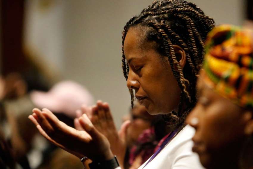 A woman prays during a healing Mass at St. Martha Church in Uniondale, N.Y.