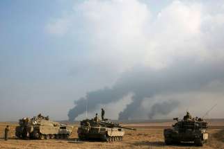 Israeli soldiers stand atop tanks outside the northern Gaza Strip July 22. Israel pounded targets across the Gaza Strip July 22, saying no cease-fire was near as top U.S. and U.N. diplomats pursued talks on halting fighting that has claimed more than 50 0 lives, mostly Palestinians.