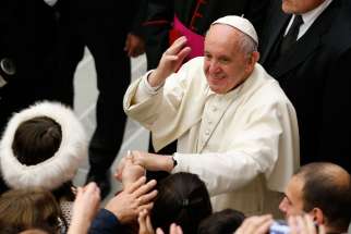 Pope Francis greets the crowd during his general audience in Paul VI hall at the Vatican Nov. 30.