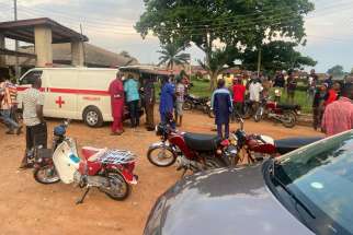 Relatives of churchgoers who were attacked by gunmen during Pentecost Mass at St. Francis Xavier Church, gather as health workers attend to victims brought in by ambulance after the attack in Owo, Nigeria, June 5, 2022. Reports said at least 50 people were killed in the attack.