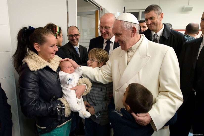 Pope Francis blesses a baby during a visit to a Caritas center for the homeless near the Termini rail station in Rome Dec. 18. The pope opened a Door of Mercy at the center.