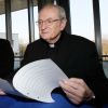 Cardinal Joachim Meisner of Cologne, Germany, looks over the program for the annual meeting of the German bishops conference in Trier Feb. 18. At left is Cardinal Reinhard Marx of Munich. Both cardinals are eligible to take part in the upcoming conclave.