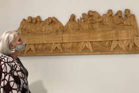 Connie Leon looks over The Last Supper wood relief carving she donated to St. Joseph’s Morrow Park Catholic Secondary School.