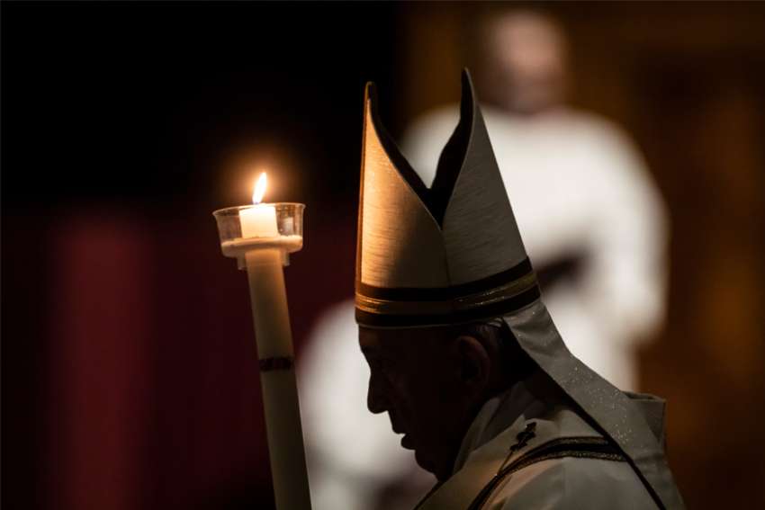 Pope Francis carries a candle as he celebrates the Easter vigil in St. Peter&#039;s Basilica at the Vatican April 11, 2020.