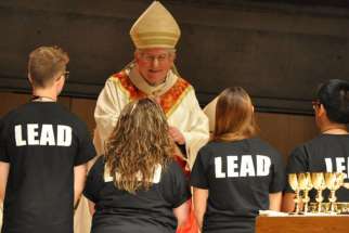 Cardinal Collins blesses the LEAD volunteers as they each give the gifts to him.