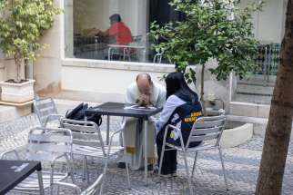 A priest hears confession from a pilgrim at the recent World Youth Day in Portugal.