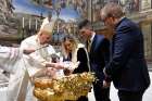 Pope Francis baptizes one of 13 babies during a Mass celebrating the feast of the Baptism of the Lord in the Sistine Chapel at the Vatican Jan. 8, 2023.