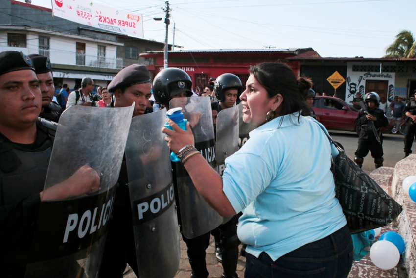 A woman shouts slogans in front of riot police officers during a prayer service for the release of political prisoners Aug. 28, 2019, in Masaya, Nicaragua. The Society of Jesus has urged Latin American countries, working &quot;through international diplomacy,&quot; to &quot;take all the necessary measures to rescue democracy in Nicaragua and hold the current regime responsible for the crimes it has committed.&quot;