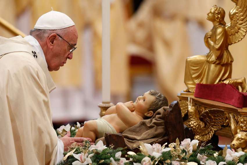 Pope Francis touches a figurine of the infant Jesus at the start of Mass marking the feast of the Epiphany in St. Peter&#039;s Basilica at the Vatican Jan. 6, 2015.