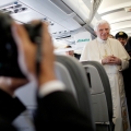 Pope Benedict XVI smiles for a photographer after answering reporters&#039; questions during a news conference aboard his flight to Madrid Aug. 18.