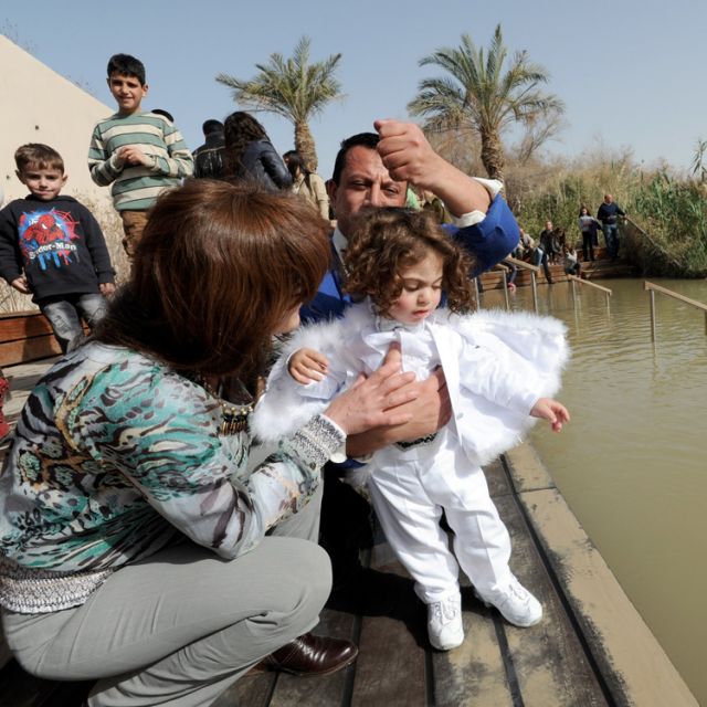Palestinian Catholics from Jerusalem, Najed Mishriki, 40, and his wife, Mary, 40, sprinkle their son, Khamis, 18 months, by the Jordan River on the Feast of the Baptism of the Lord Jan. 8. Located near the West Bank town of Jericho, the site is believed to be the place where St. John baptized Jesus.
