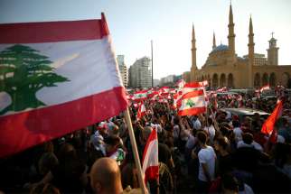 Demonstrators near Al-Amin mosque in Beirut carry national flags during an anti-government protest Oct. 20, 2019. Fueled by economic insecurity and deteriorating living conditions, protests were sparked by government plans to impose new taxes.