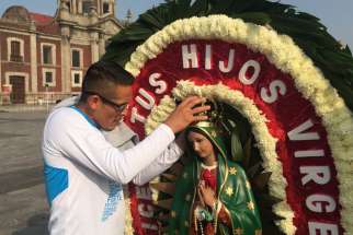 A man adjusts the crown on a statue of Our Lady of Guadalupe Dec. 6 outside the basilica named for her in northern Mexico City. The national patroness remains important in Mexico as source of spiritual inspiration, but even nonoreligious people identify with her.