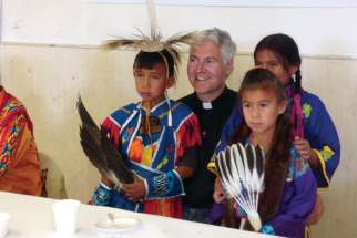 Archbishop Murray Chatlain, with First Nations children in this Register file photo, says the Catholic Church has to be there for families facing despair on a daily basis. Recently, six youth have taken their lives in his Keewatin Le-Pas diocese.