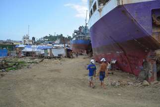 In this spring 2014 picture, residents of the Anibong shoreline shanty community coexist with cargo ships that ran aground in their neighborhood after Super Typhoon Haiyan slammed the central Philippines in November 2013.