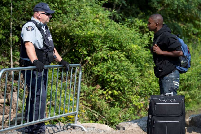 A migrant confronts a police officer at the infamous Roxham Road “irregular” border crossing between Quebec and New York state.