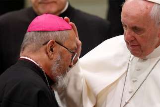 Pope Francis greets Archbishop Anthony S. Apuron of Agana, Guam, during his general audience in Paul VI hall at the Vatican Feb. 7. Archbishop Apuron has been away from Guam during a Vatican-led investigation of allegations that he sexually abused several boys, allegations he strongly disputes.