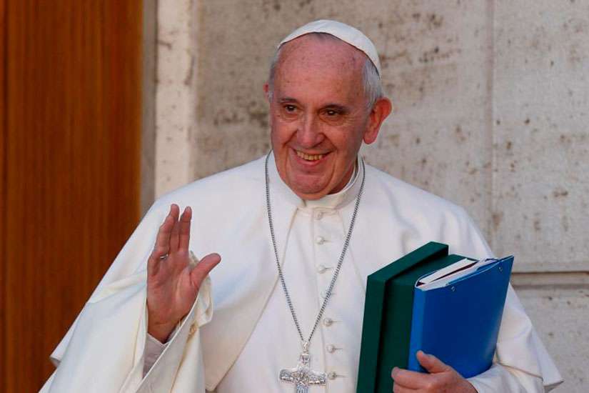 Pope Francis waves as he leaves a session of the Synod of Bishops on the family at the Vatican Oct. 24.
