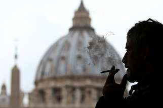 A man smokes a cigarette in front of St. Peter Square at the Vatican Nov. 9. Pope Francis has decided that the Vatican will stop selling cigarettes to its employees in 2018 because of the health risks of smoking. 