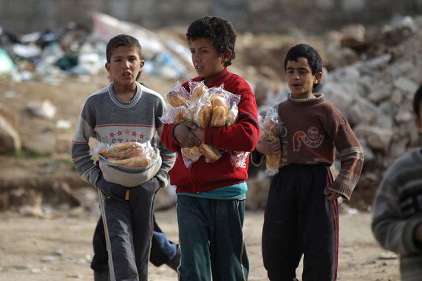 Boys carry sandwiches Jan. 20 in Aleppo, Syria. Conveying Pope Francis&#039; closeness to the Syrian people, a Vatican delegation visited Aleppo Jan. 18-23 following the end of the hostilities that left thousands dead and the city in ruins. 