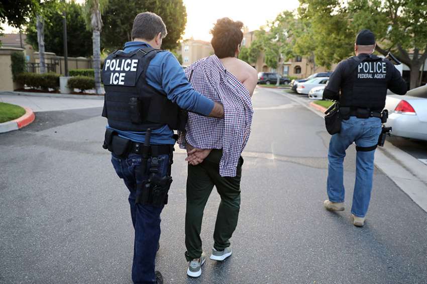 A U.S. Immigration and Customs Enforcement official arrests an Iranian immigrant in San Clemente, Calif., May 11.