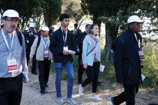 Sebastian Duhau, a synod observer from Australia, and Emilie Callan, a synod observer from Canada, participate in a pilgrimage hike from the Monte Mario nature reserve in Rome to St. Peter&#039;s Basilica at the Vatican Oct. 25. Participants in the Synod of Bishops on young people, the faith and vocational discernment, and young people from Rome parishes took part in the hike. 