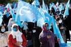 Ethnic Uighur women wave flags of the East Turkestan independence movement during a protest in Istanbul Oct. 1, 2020.