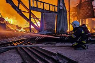 Firefighters work at the site of an industrial warehouse destroyed by a Russian drone strike in Lviv, Ukraine, Sept. 19, 2023.