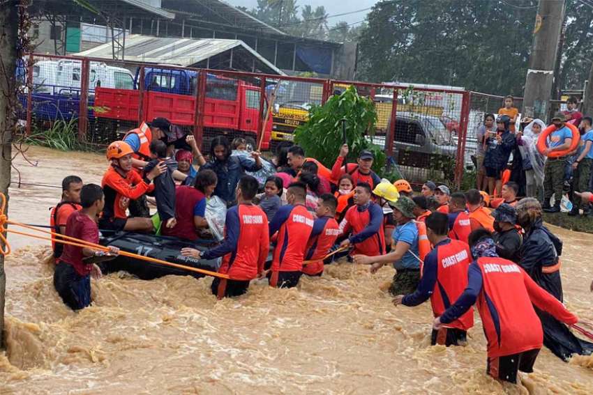 Philippine Coast Guard personnel rescue residents stranded by floods caused by Typhoon Rai in Cagayan de Oro, Philippines, Dec. 16, 2021. The storm has claimed more than 200 lives and Caritas Philippines has appealed for donations to bolster its emergency response.