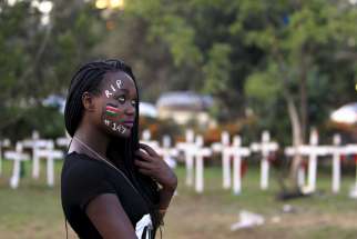 A student wearing face paint walks past wooden crosses during an April 14 memorial concert in Nairobi, Kenya, for the 147 people killed in an attack on Garissa University College. Pope Francis is calling for perpetrators of extremist violence in Kenya &quot;t o come to their senses and seek mercy.&quot; 