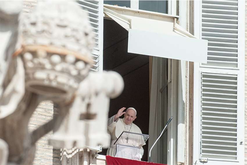Pope Francis greets the crowd from the window of his studio overlooking St. Peter&#039;s Square as he leads the Angelus at the Vatican Oct. 4, 2020.