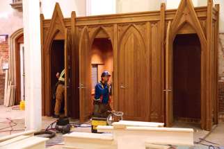 A workman completes the installation of one of the cathedral’s new confessionals.
