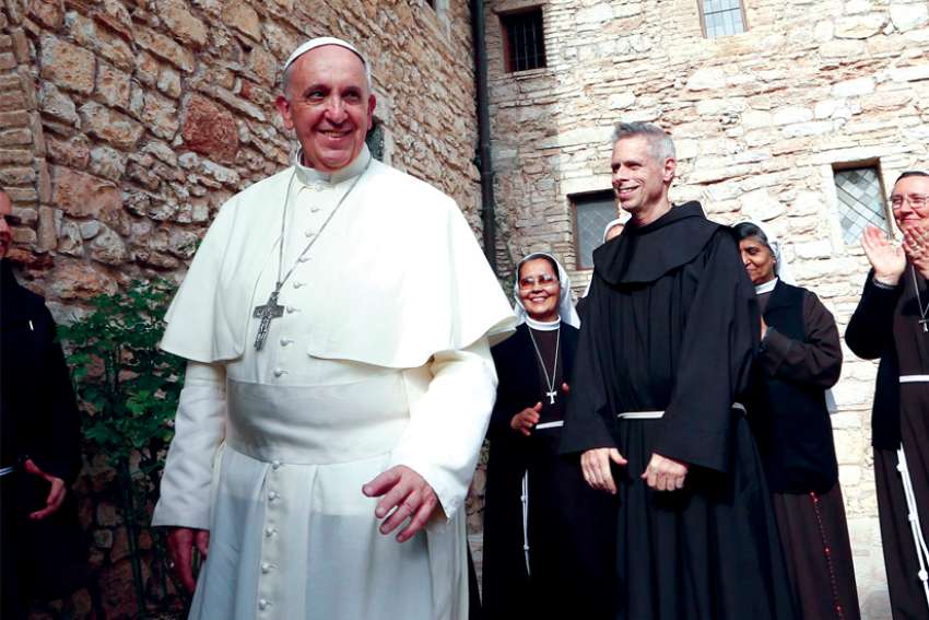 Pope Francis greets religious as he leaves the hermitage and cell of St. Francis in Assisi, Italy, in this Oct. 4, 2013, file photo. The Pope plans to visit Assisi on Oct. 3 to sign his new encyclical on human fraternity.