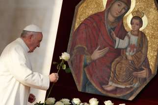 Pope Francis presents a rose at an icon of Mary and the child Jesus as he begins his general audience in St. Peter&#039;s Square at the Vatican Dec. 9.