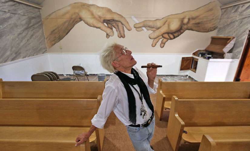 Bill Levin poses in the sanctuary at The First Church of Cannabis, on June 23, 2015. The sanctuary, still under renovation, includes a painting on the back wall of two hands passing a cannabis cigarette. The painting, by CS Stanley, the church’s minister of art, is similar to a detail of the Michelangelo “Creation of Adam” on the Sistine Chapel ceiling.