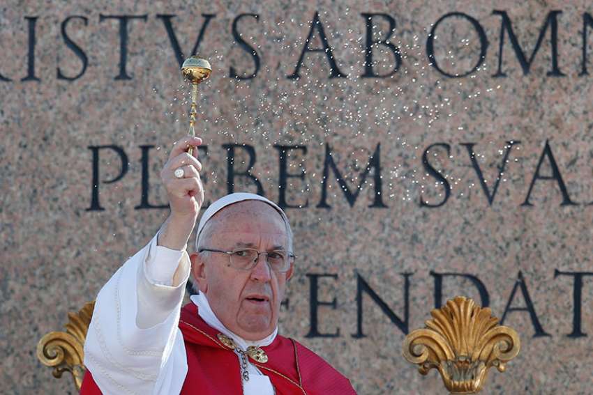 Pope Francis blesses the faithful with holy water as he celebrates Palm Sunday Mass in St. Peter&#039;s Square at the Vatican April 9.