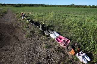 Shoes are seen on a path leading to the former Brandon Indian Residential School June 12, 2021. Researchers -- partnered with the Sioux Valley Dakota Nation -- located 104 potential graves at the site in Brandon, Manitoba.