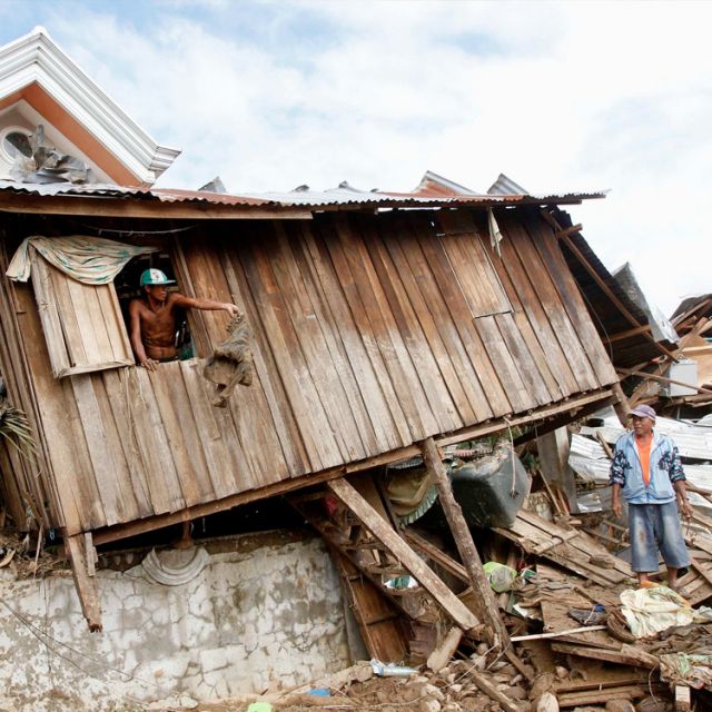 Residents retrieve belongings from a house after it was swept away by flash floods caused by Typhoon Washi in a subdivision in Iligan, Philippines, in this Dec. 19 photo. Catholic agencies and officials in the Philippines are working to provide housing f or victims of recent flooding that left more than 1,200 people dead and hundreds of thousands more displaced. 