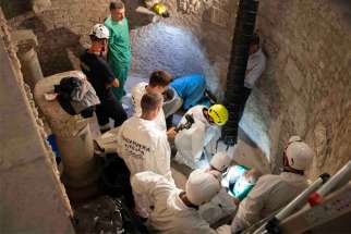 Workers inspect an ossuary at the Teutonic Cemetery at the Vatican July 20, 2019. The ossuary was inspected in the hope of finding the missing remains of a German princess and duchess and possibly the remains of Emanuela Orlandi, who disappeared in 1983. Thousands of bones were found in the ossuary, according to a representative of the Orlandi family who was present for the search.