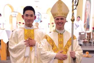 Fr. Tai Le with Prince Albert Bishop Stephen Hero after Le was ordained to the priesthood this summer.