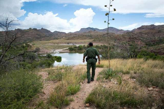 Border Patrol Agent Bryan Flowers walks above Pena Blanca Lake, a small recreation area about 17 miles northwest of Nogales, Ariz., July 16. Because of the water availability, smuggling routes through this region are common, Flowers said.
