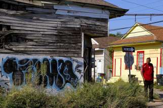 A man walks past an abandoned building in the Upper Ninth Ward neighborhood of New Orleans Aug. 1. More than a decade after Hurricane Katrina, the city continues to rebuild.